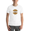 Person wearing the TRIAL AND ERROR. white unisex T-shirt: an ochre circle with the black label TRIAL AND ERROR. – museum-label-style typography tee by ALL4SI